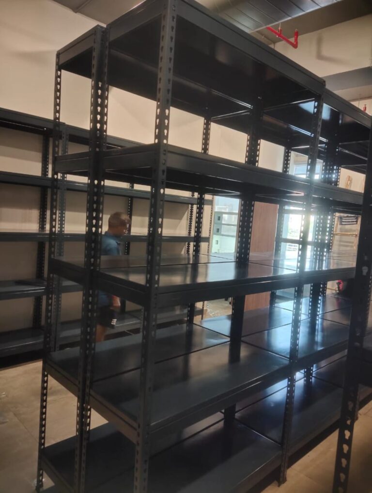 boltless rack of dark grey color installed at an office for storage purpose. 36 inches width, 15 inches depth, 5 shelves and 6feet height. wall is white in color.