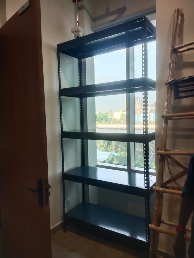 boltless rack of dark grey color installed at an office for storage purpose. 36 inches width, 15 inches depth, 5 shelves and 6feet height. wall is white in color.