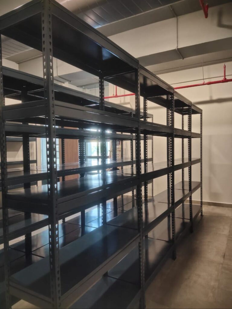 boltless racks of dark grey color installed at an office for storage purpose. 36 inches width, 15 inches depth, 5 shelves and 6feet height. wall is white in color.