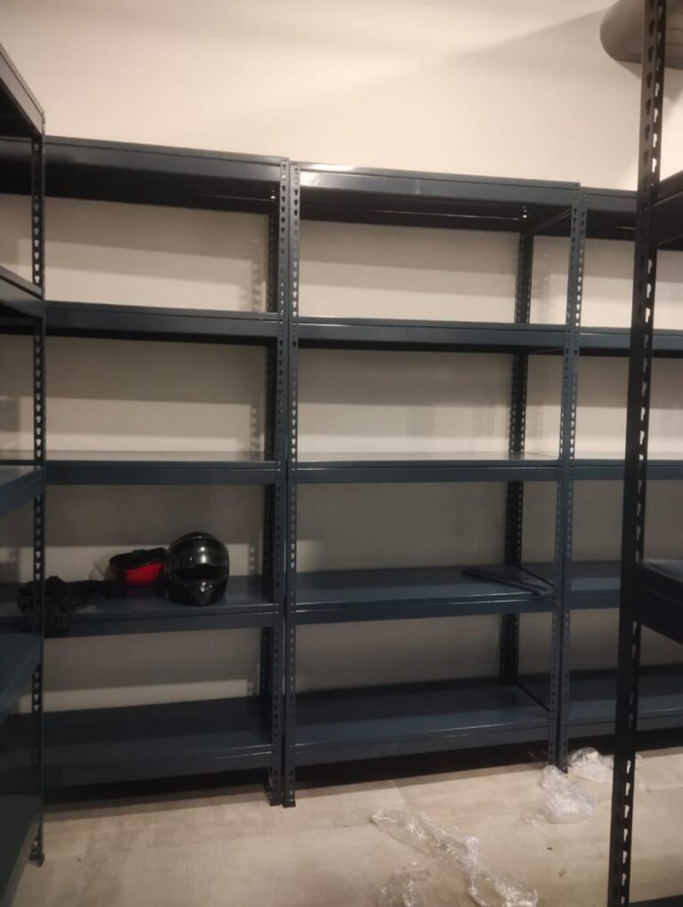 boltless racks of dark grey color installed at an office for storage purpose. 36 inches width, 15 inches depth, 5 shelves and 6feet height. wall is white in color.